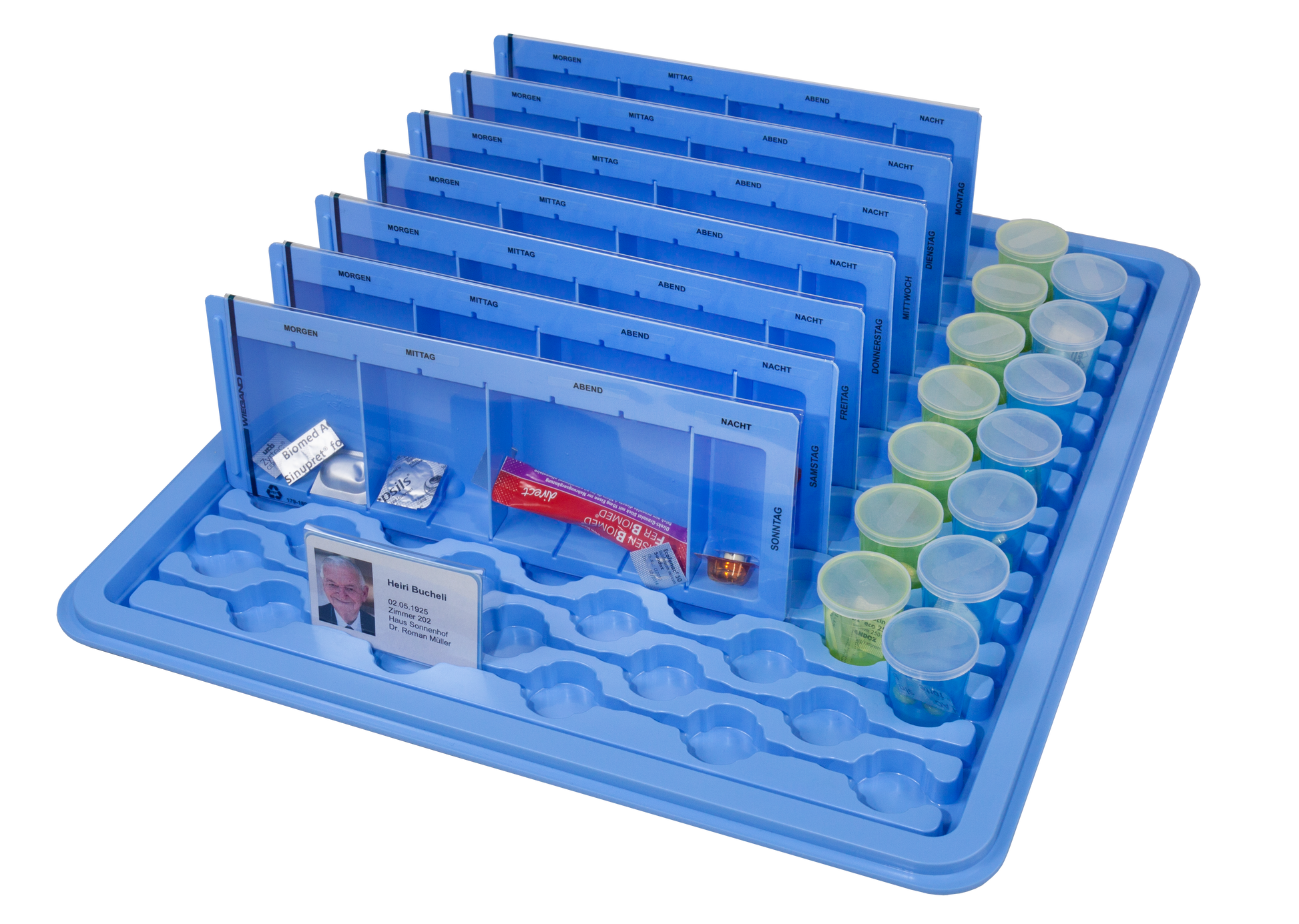 Wiegand medicinbakke med fire doseringssektioner – morgen, middag, aften og nat – samt patientkort og farvekodede medicinbægre til sikker medicinhåndtering